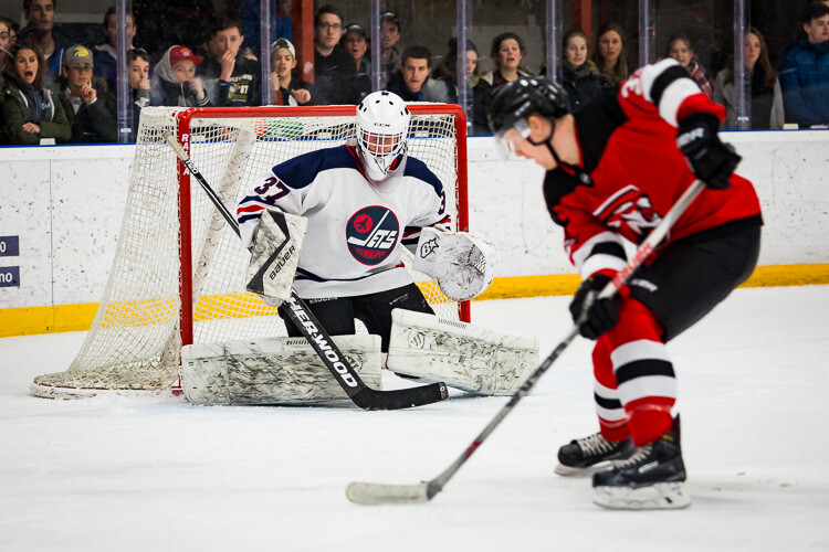 A hockey player on a breakaway against a goaltender - Tips for Editing Hockey Photos in Lightroom