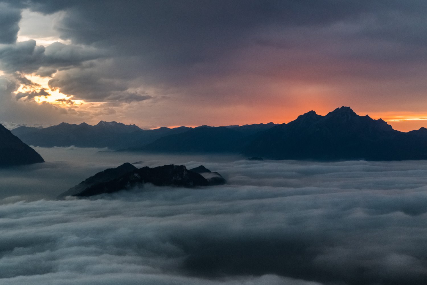 clouds below the mountains
